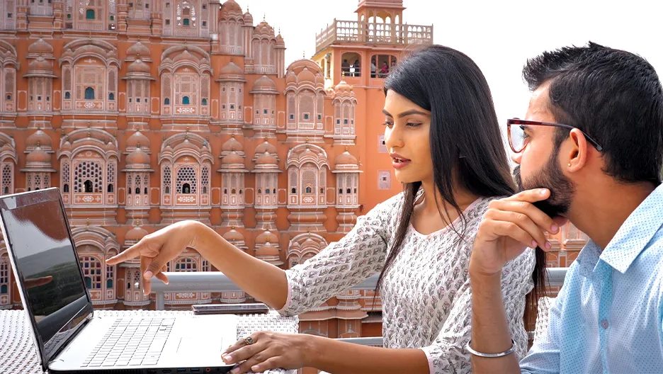 Indian woman and man working on laptop