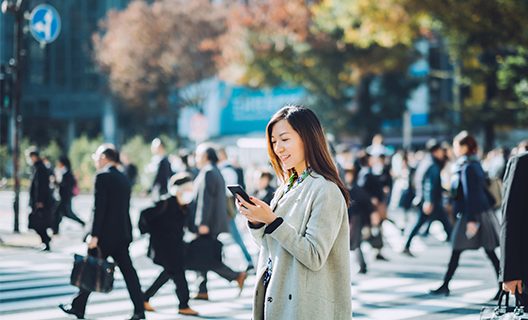 A woman dressed in a business suit is using her cell phone