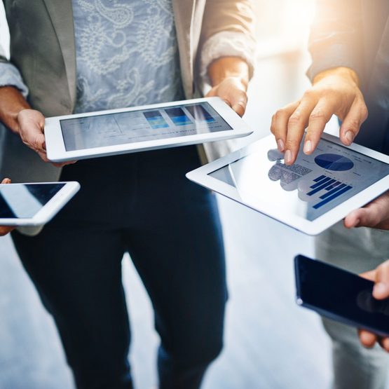 group of people using tablets and mobile phones to work