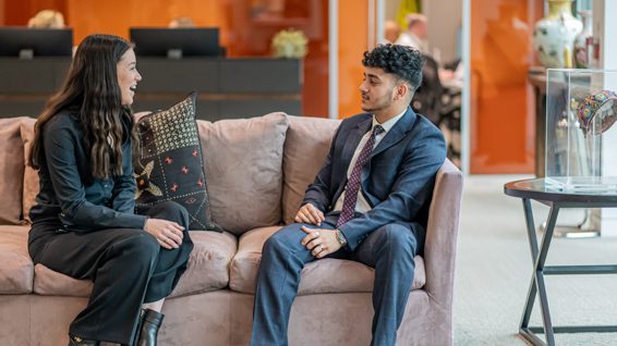 two workers talking on a sofa