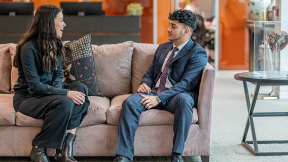 two workers talking on a sofa