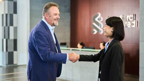 man and woman shaking hands in office