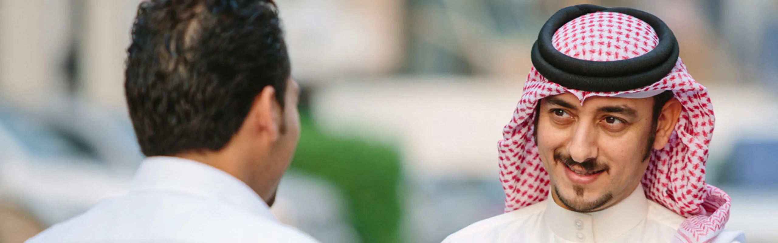 Two businessmen discuss banking in the street.