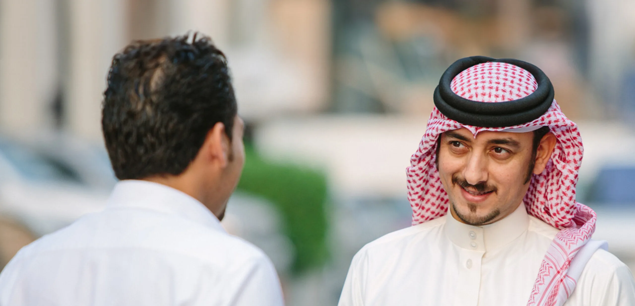 Two businessmen discuss banking in the street.