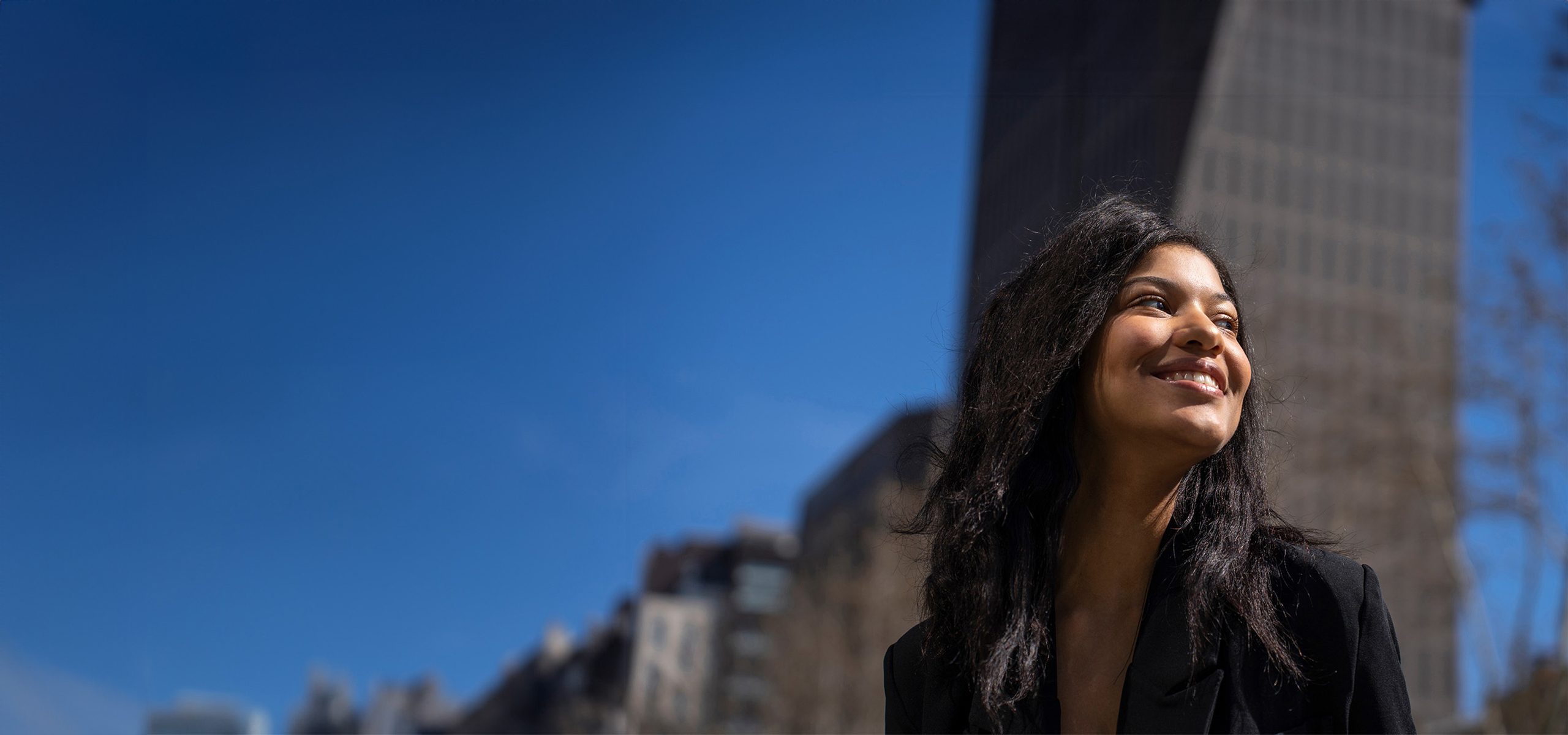 A smiling woman in a city centre.