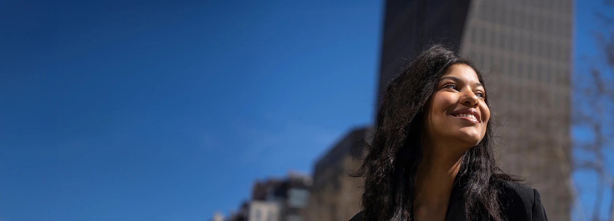 A smiling woman in a city centre.