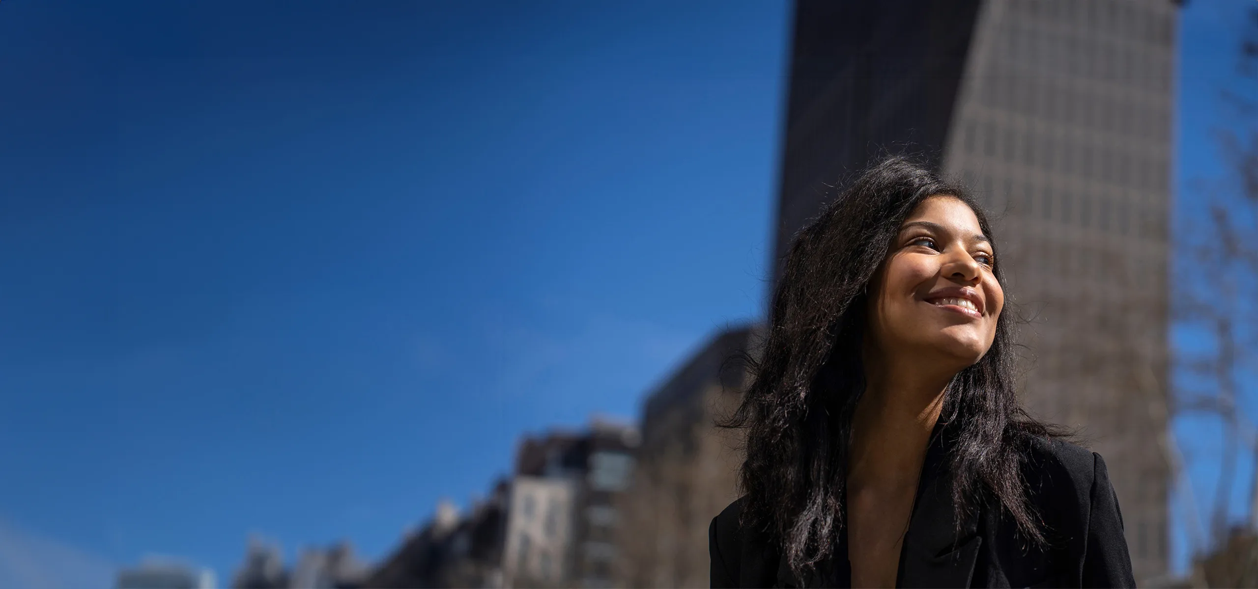 A smiling woman in a city centre.