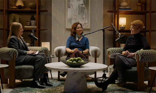 Three women in a podcast studio having a friendly conversation during Episode 2.