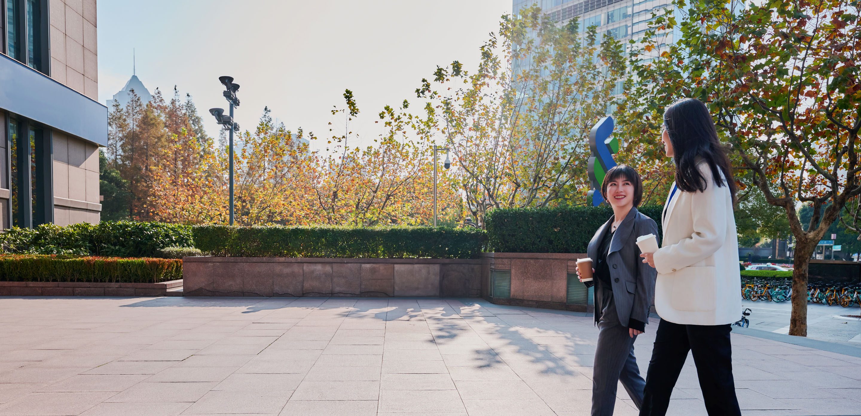 Two Standard Chartered colleagues have a conversation outside an office