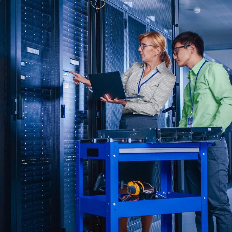 Two people work in a data center.