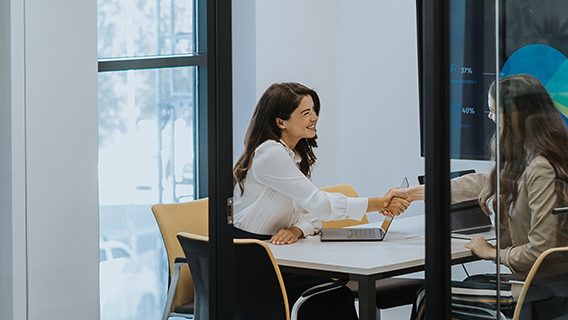 Two women work on a sustainable finance deal.