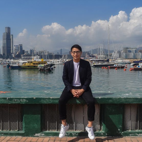 William Luk sitting in front of harbor