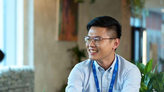 A young man in a blue shirt in an office.