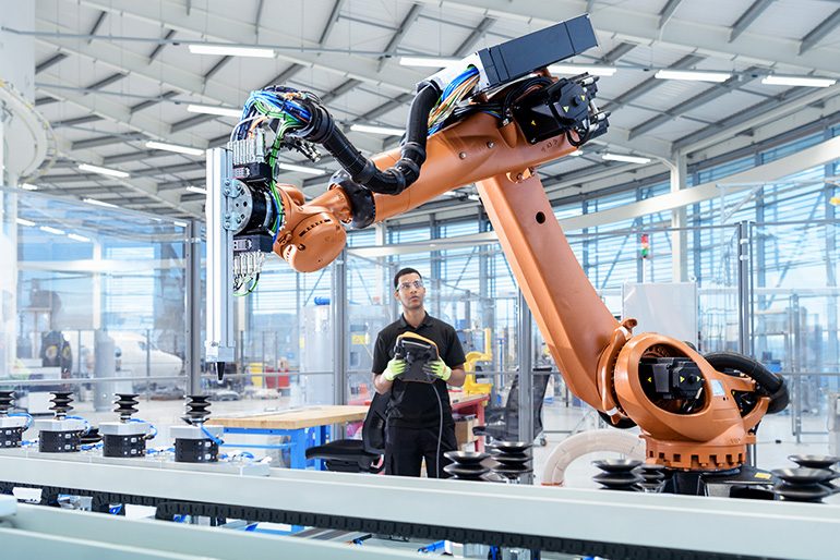 Image of a man controlling a machine in a factory