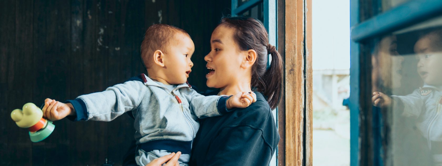 A woman holding a child masthead