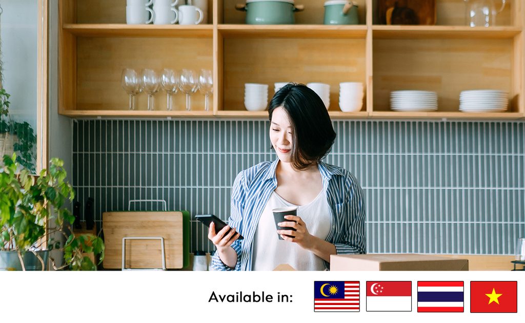 woman using phone and holding cup