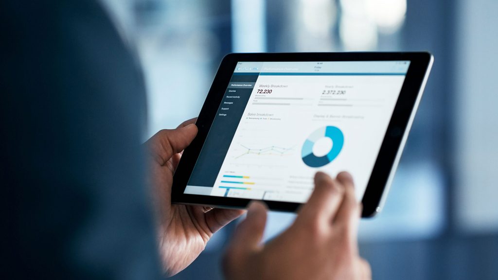 image of a person analysing data on a tab