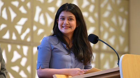 A smiling girl talking over the microphone
