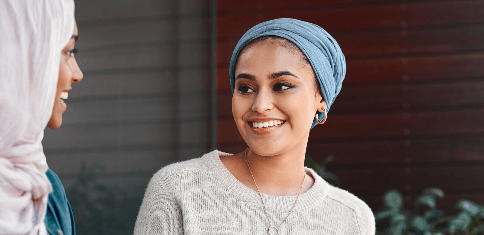 A smiling woman with a blue head scarf