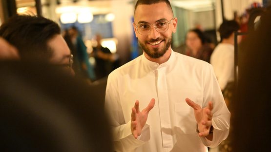 A white guy wearing a glasses is smiling