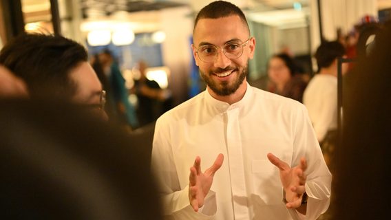 A white guy wearing a glasses is smiling