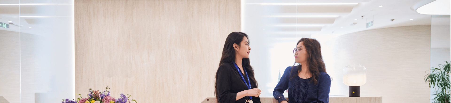 Two women talking in the office reception
