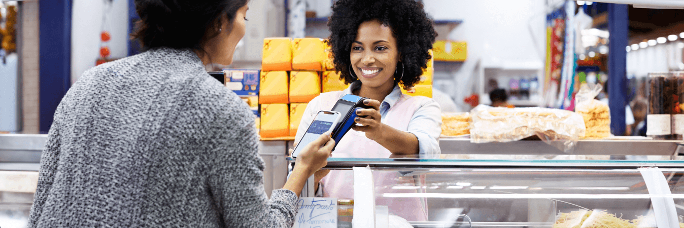 woman using smartphone to pay for produce