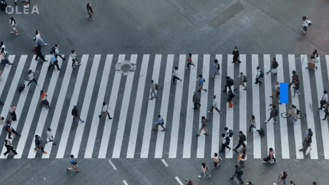 Group of people walking across a zebra crossing on a busy street