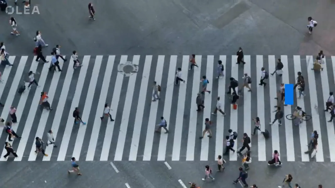 Group of people walking across a zebra crossing on a busy street
