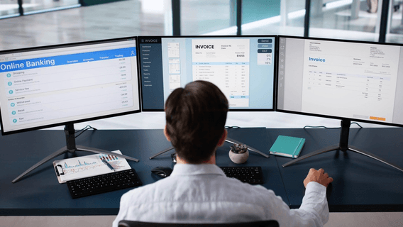 Man working in front of 3 computer screens