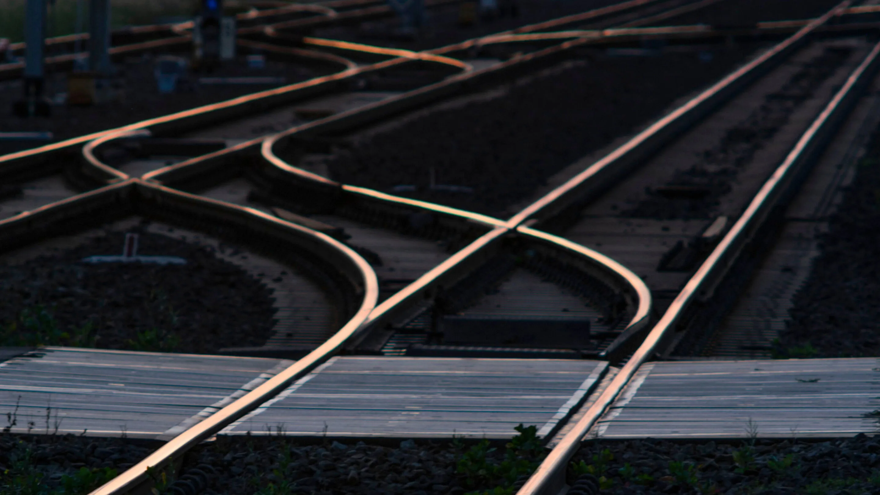 Railway tracks converging and crossing through a rail yard.