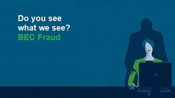 Fraudster looming over victim sitting in front of computer