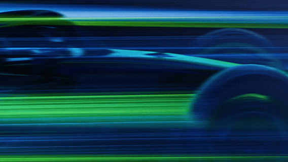 Blue and green light blurs across the screen. From the streaks of colour, the shape of a car emerges.