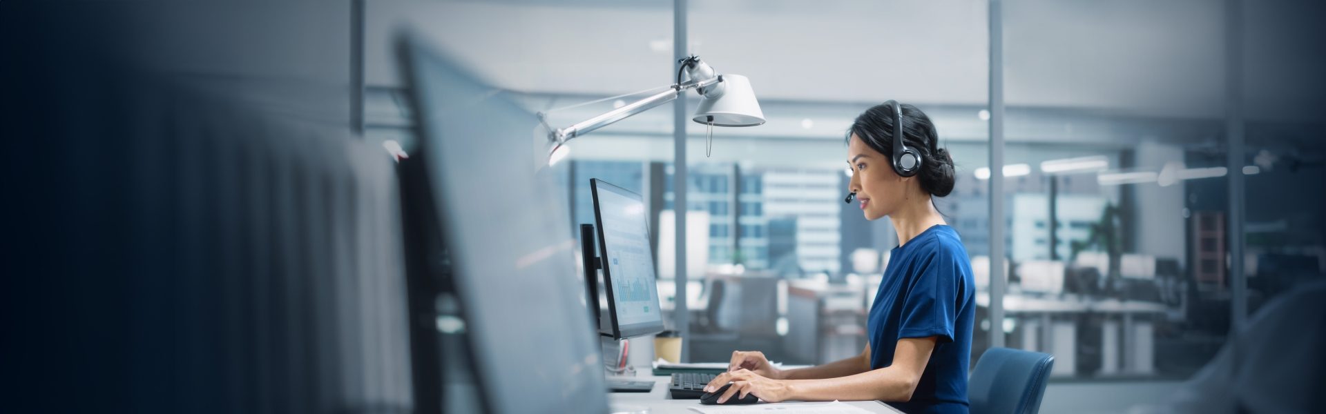 Woman with headset on working on computer