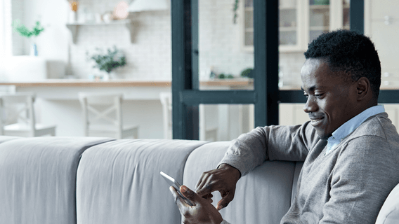 A man reads economic news and insights on his mobile phone.