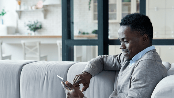 A man reads economic news and insights on his mobile phone.