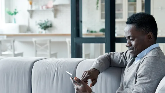 A man reads economic news and insights on his mobile phone.