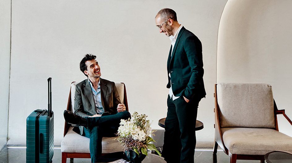 A business traveler speaking to a man in suit