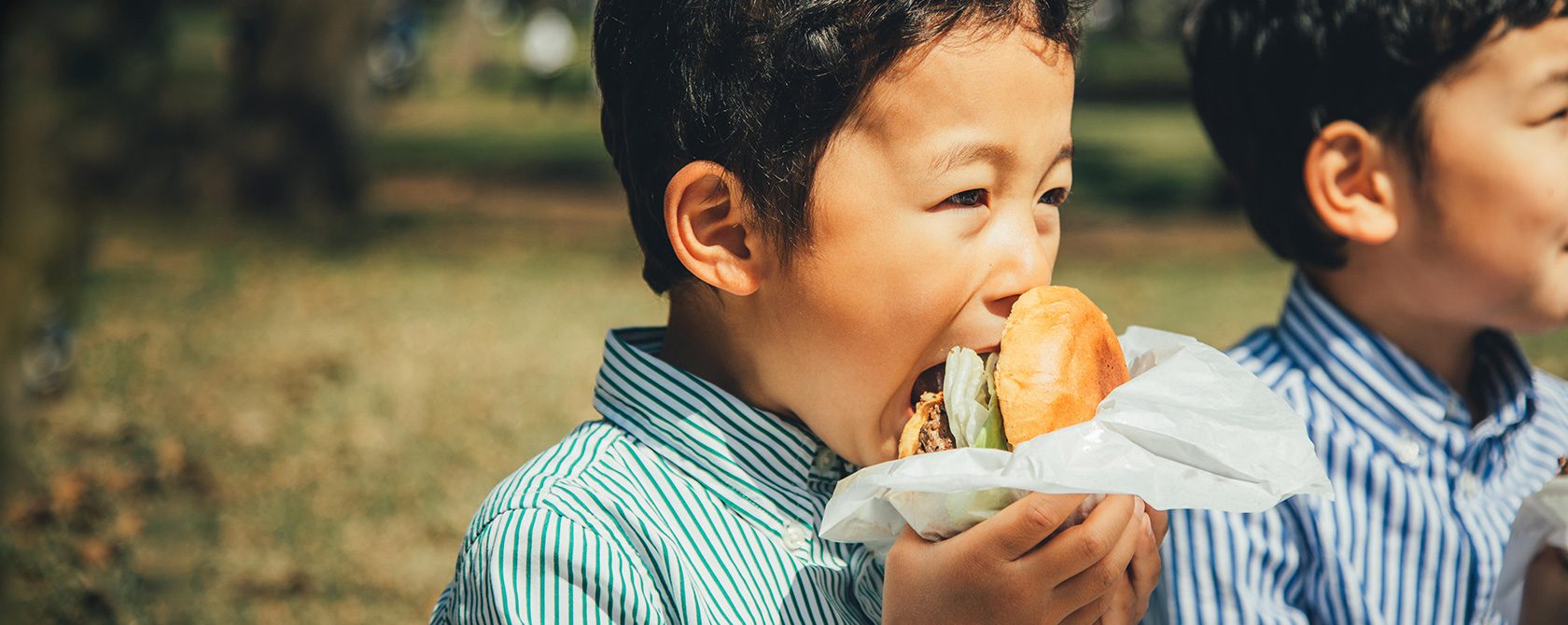 A child biting into a burger