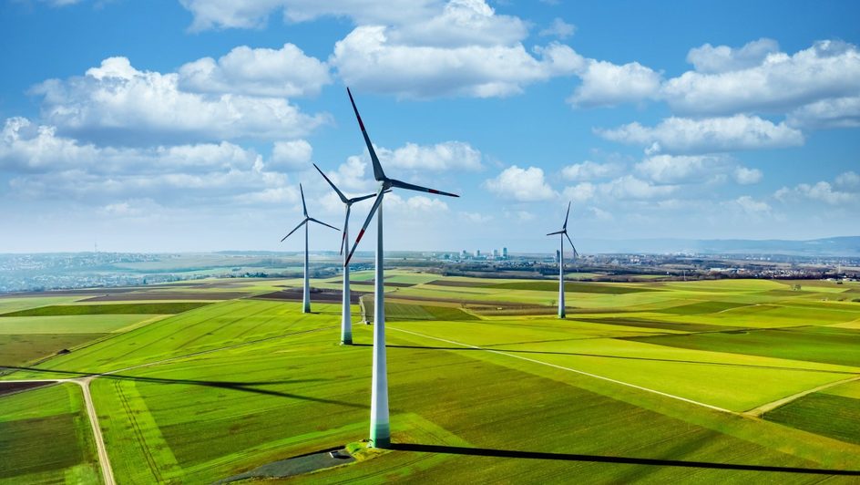 image of wind turbines in green field