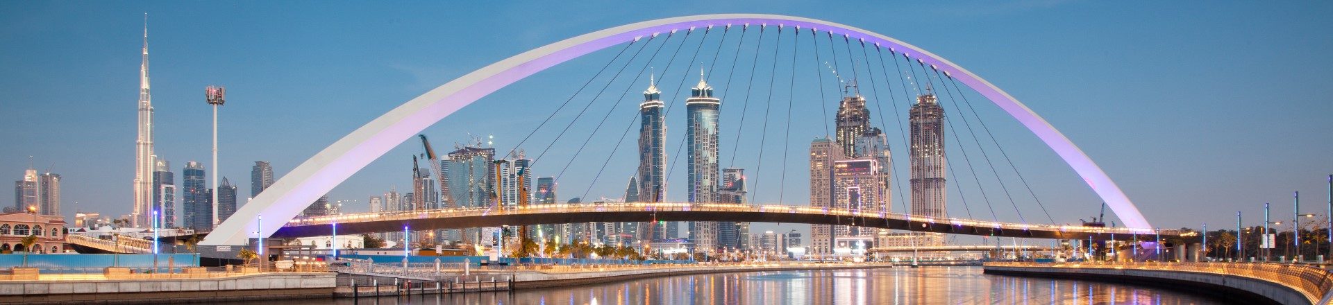 skyline image of Dubai at dusk with bridge in the foreground