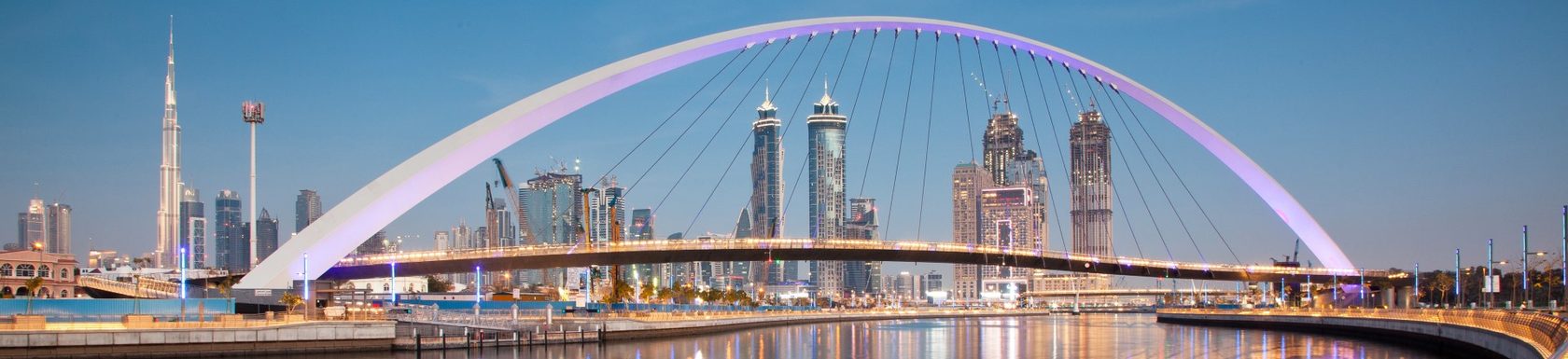 skyline image of Dubai at dusk with bridge in the foreground