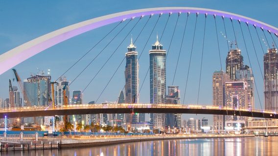 skyline image of Dubai at dusk with bridge in the foreground