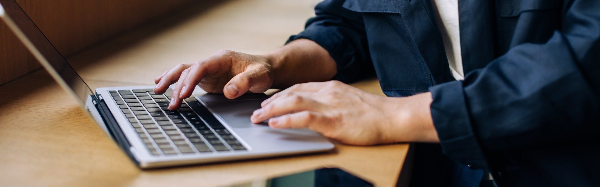 close of hands typing on laptop