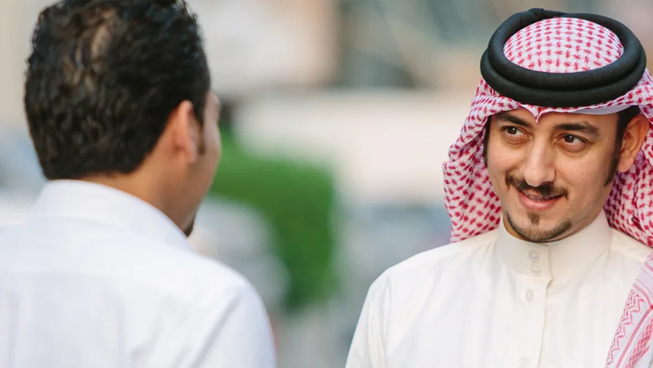 Two businessmen discuss banking in the street.