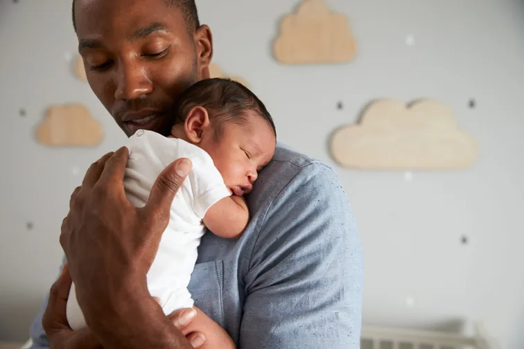 A father cradles his newborn child.