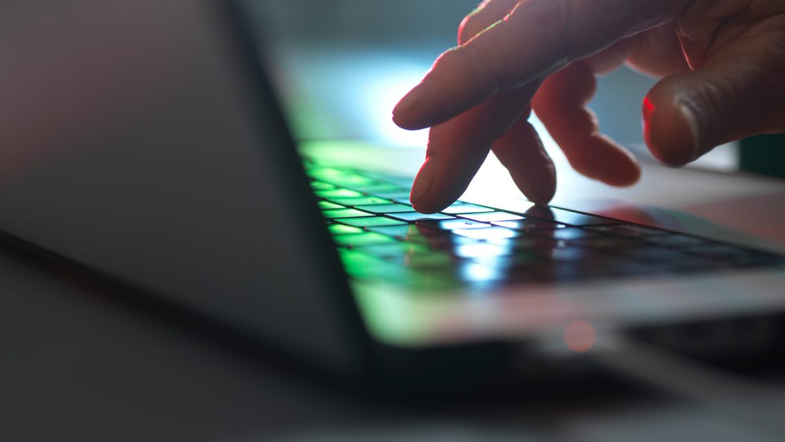 A person uses a laptop to set up AI-enabled financial crime controls.
