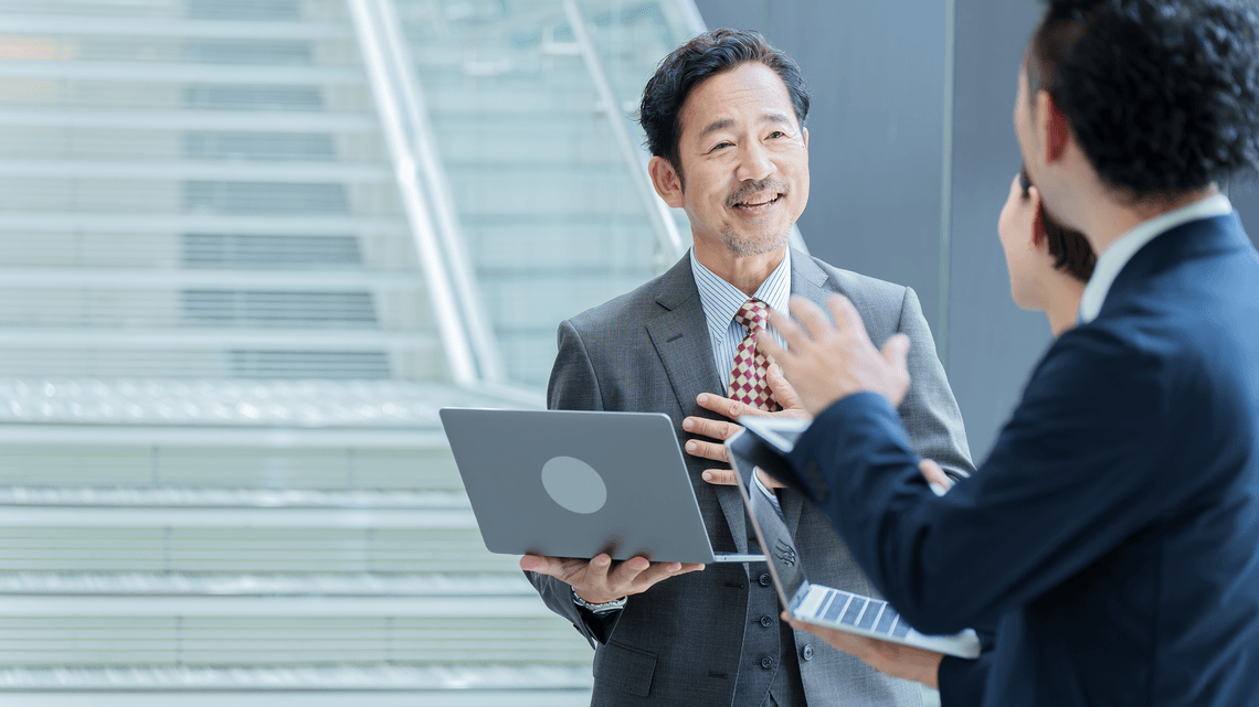 colleagues standing and speaking with laptop