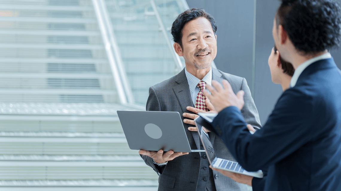 colleagues standing and speaking with laptop