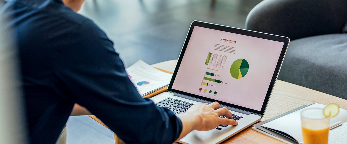 A man with a laptop rworking on a business report